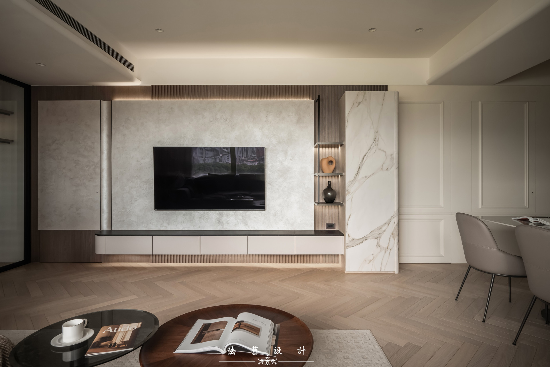 電視牆採用藝術塗料搭配深色木紋格柵，營造出沉穩大氣的視覺效果；旁邊的大理石紋薄櫃磚更是畫龍點睛，為整體空間增添細膩質感，讓客廳呈現出既有格調又和諧統一的美感。